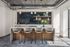 island bar with grey stool, navy ceramic tile wall, shelves with decor