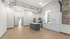 Modern industrial-style kitchen with exposed ductwork, sleek cabinetry, stainless steel appliances, and a central island, complemented by a natural stone accent wall and abundant natural light.