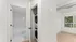Modern apartment interior featuring a sleek in-unit washer and dryer with a bright bathroom, complemented by large windows for natural light.