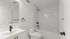 Modern bathroom with sleek black fixtures, elegant white vanity, and a spacious bathtub.