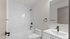 Modern bathroom featuring sleek fixtures, elegant bathtub, and stylish vanity with a large mirror.