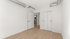 Chic and modern bedroom with sleek hardwood floors, pristine white walls, and stylish exposed ductwork, offering a minimalist and airy vibe.