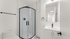 Modern bathroom featuring a sleek glass shower enclosure, white vanity with a chic faucet, and contemporary lighting.