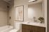 Modern bathroom with sleek fixtures, elegant bathtub, stylish vanity, and contemporary wall art, creating a serene and inviting atmosphere.