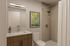 Contemporary bathroom with sleek fixtures, modern shower, elegant mirror, and stylish wall art.