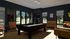 Elegant game room with a sleek billiard table, plush seating, and large windows offering a scenic garden view.
