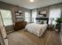 Inviting bedroom with a plush bed, two elegant side tables, and modern decor, featuring soft lighting and large windows for natural light.
