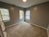 Inviting bedroom with plush carpet, neutral walls, and abundant natural light from dual windows.