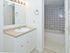 Bathroom with beige and white vanity mirror at Gladstone Towers apartments for rent in Lansdowne, PA