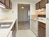 Galley kitchen with brown cabinets and white appliances