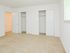 Carpeted model bedroom with 2 closets at Rolling Glen Townhomes and Apartments in Boothwyn, PA.