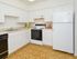 Model kitchen with parquet-style floors and modern appliances at Valley Stream Apartments in Lansdale, PA.