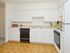 Model kitchen with parquet-style floors and modern appliances at Valley Stream Apartments in Lansdale, PA.