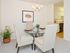 Dining area furnished with a circular table and 4 chairs looking into the kitchen at Valley Stream Apartments in Lansdale, PA.