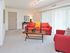 Carpeted living room furnished with a couch and upholstered chair at Valley Stream Apartments in Lansdale, PA.