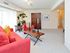 Carpeted living room furnished with a couch and upholstered chair at Valley Stream Apartments in Lansdale, PA.