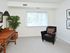 Carpeted bedroom with large windows that has been furnished with a desk and chair.