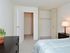 Carpeted bedroom with a large bed, nightstand and dresser at Valley Stream Apartments in Lansdale, PA.
