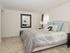 Furnished apartment bedroom with windows and plush carpeting