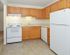 Kitchen with white appliances and wood cabinets at Boothwyn Court apartments for rent
