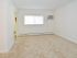 Living room with a window and air conditioning unit at Boothwyn Court apartments for rent
