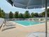 Large swimming pool surrounded by lounge chairs and shade umbrellas