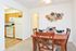Dining Room furnished with a rectangle table and 4 chairs looking into the kitchen at Naamans Village Apartments in Claymont, DE.