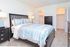 Carpeted master bedroom with a large bed, 2 nightstands and a dresser at Naamans Village Apartments in Claymont, DE.