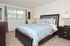 Carpeted master bedroom with a large bed, 2 nightstands and a dresser at Naamans Village Apartments in Claymont, DE.