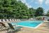Outdoor swimming pool with lounge chairs and umbrellas at Allandale Village apartments for rent