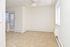 Carpeted living room with a ceiling fan, large windows and in-wall A/C unit at Norriton East Apartments in East Norriton, PA.