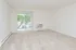 Carpeted living room with sliding glass patio doors and in-wall A/C unit at The Lafayette at Valley Forge apartments in King of Prussia, PA.