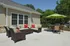 Large patio outside the community center with outdoor furniture and tables with umbrellas at The Lafayette at Valley Forge apartments in King of Prussia, PA.