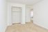 Large bedroom with white walls and doors and beige carpeting