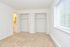 Apartment bedroom with carpeted floors, two closets, and a large window