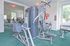 Strength training machines in fitness center with natural light and green carpet