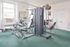 Green carpeted fitness center with strength training equipment