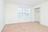 Carpeted bedroom with a large window and closet at Willow Run Apartments in Willow Grove, PA.