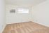 Carpeted living room with a large window and an in-wall A/C unit at Woodview Apartments in Media, PA.