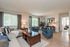 Spacious living area with hardwood floors, large windows, and sliding glass doors out to a balcony