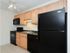 Kitchen with brown cabinets and black appliances at Concord Court apartments for rent in Aston, PA