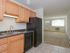 Kitchen with brown cabinets and black appliances at Concord Court apartments for rent in Aston, PA