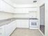 Bright kitchen with white cabinets and appliances