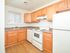 Kitchen with brown cabinets and white appliances at Cedar Tree Village apartments for rent