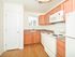 Bright kitchen with small window, white appliances, and pantry