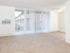 A spacious living room with sliding doors leading to a balcony view at Black Hawk apartments for rent