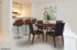 Model dining room with a circular table and 4 chairs looking towards the breakfast bar in the kitchen.