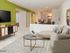 Carpeted living room is furnished with an L-shaped couch, coffee table and TV stand at Waterloo Place Apartments in Baltimore, MD.