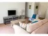 Model living room furnished with a couch, coffee table and upholstered chair at Winslow House Apartments in Blackwood, NJ.
