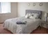 Carpeted model bedroom furnished with a large bed and nightstand at Winslow House Apartments in Blackwood, NJ.